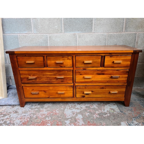 119 - A modern stained pine chest of four short over four long drawers - approx. 76cm high x 150cm wide x ... 