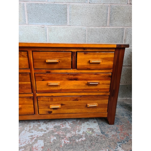 119 - A modern stained pine chest of four short over four long drawers - approx. 76cm high x 150cm wide x ... 