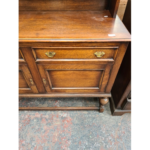 38 - A Georgian style oak dresser with upper two tier plate rack, single cupboard door, two drawers, two ... 