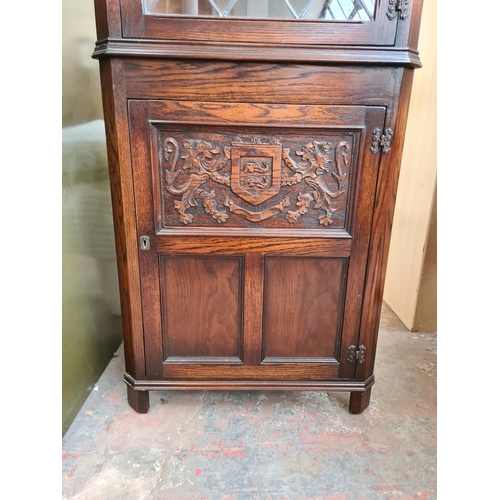 40 - A Jaycee carved oak freestanding corner cabinet with upper leaded glass door and lower cupboard door... 