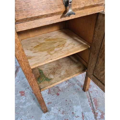 64 - An early 20th century oak bedside cabinet with one drawer and one cupboard door - approx. 82cm high ... 