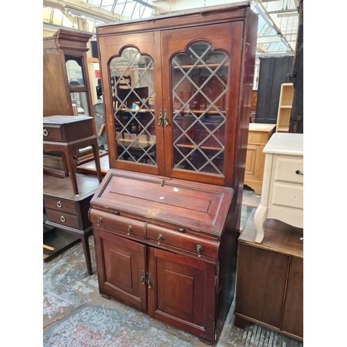 68 - A 19th century style mahogany bureau bookcase with two upper leaded glass doors, fall front, two dra... 