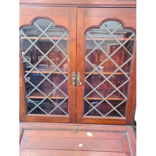 68 - A 19th century style mahogany bureau bookcase with two upper leaded glass doors, fall front, two dra... 