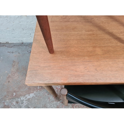 74 - A mid 20th century teak rectangular extending dining table and four teak and black vinyl dining chai... 