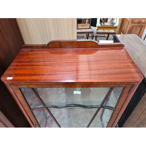 81 - A mid 20th century walnut display cabinet with single glazed door, two internal glass shelves, ball ... 