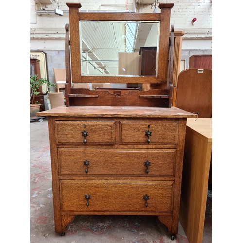 92 - An Arts & Crafts oak dressing chest with two short drawers, two long drawers and upper bevelled edge... 