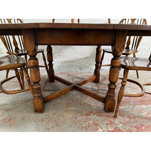 117 - A 17th century style solid oak circular extending dining table with X-frame stretcher and six Victor... 