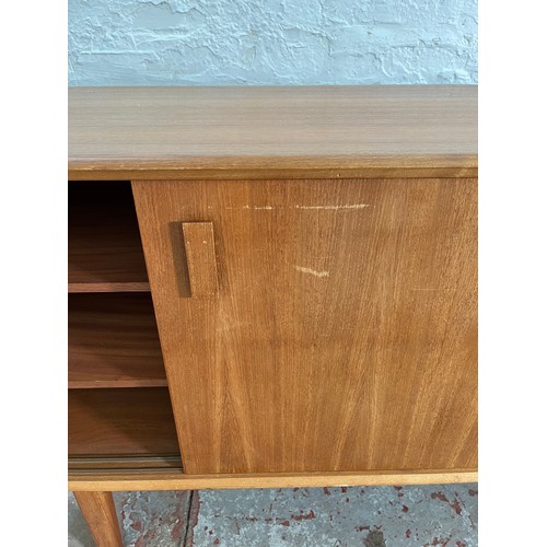 104 - A mid 20th century teak sideboard with four sliding doors, four internal drawers and shelving - appr... 