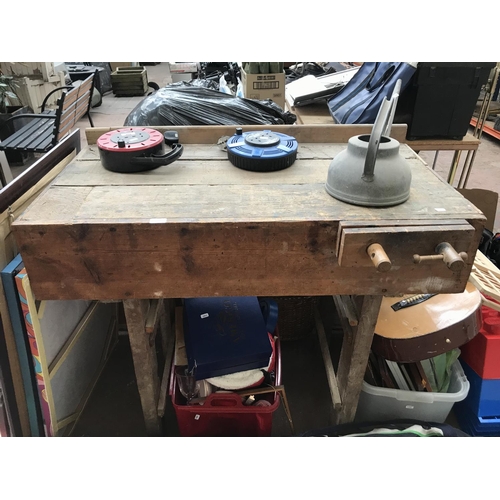 674 - A vintage work bench with wooden vice, galvanised watering can and two extension leads