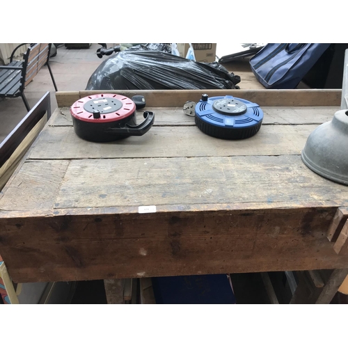 674 - A vintage work bench with wooden vice, galvanised watering can and two extension leads