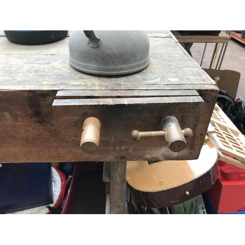 674 - A vintage work bench with wooden vice, galvanised watering can and two extension leads