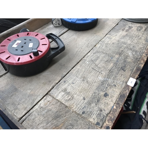 674 - A vintage work bench with wooden vice, galvanised watering can and two extension leads