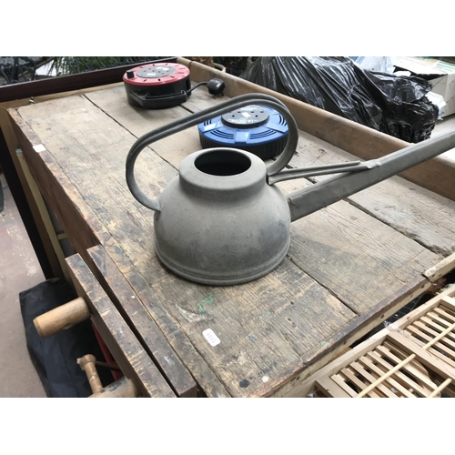 674 - A vintage work bench with wooden vice, galvanised watering can and two extension leads