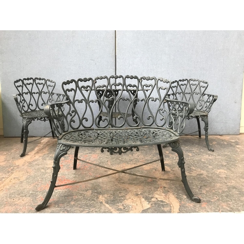 676 - A green painted cast aluminium four piece patio set comprising two seater bench, two armchairs and o... 