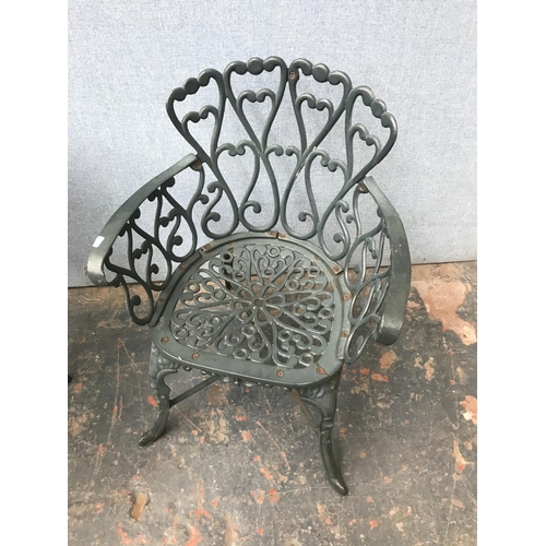 676 - A green painted cast aluminium four piece patio set comprising two seater bench, two armchairs and o... 