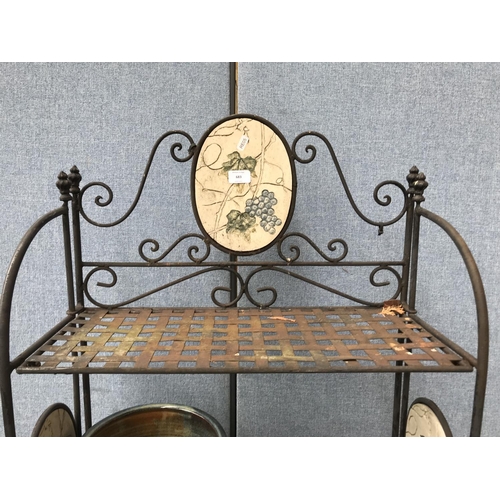 683 - A wrought iron four tier garden shelving unit with ceramic oval plaques and various planters - appro... 