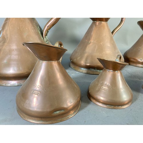 218 - Seven Victorian copper graduating imperial measuring jugs - largest approx. 28cm high