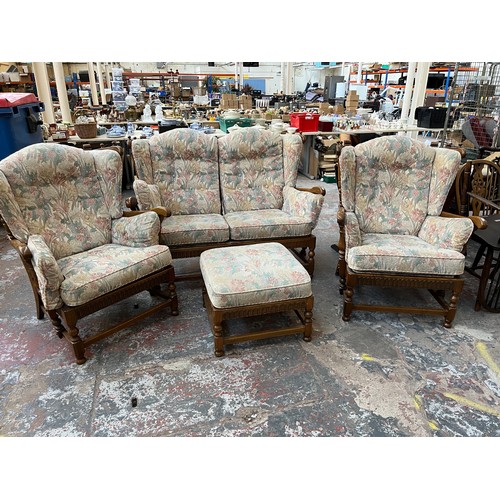 8 - An Ercol elm and floral upholstered four piece lounge suite comprising two seater sofa, two armchair... 