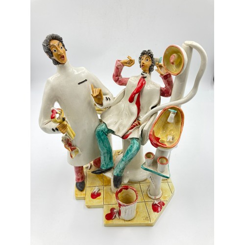 1330A - An Italian hand made ceramic figurine of a dentist and patient - approx. 26cm high