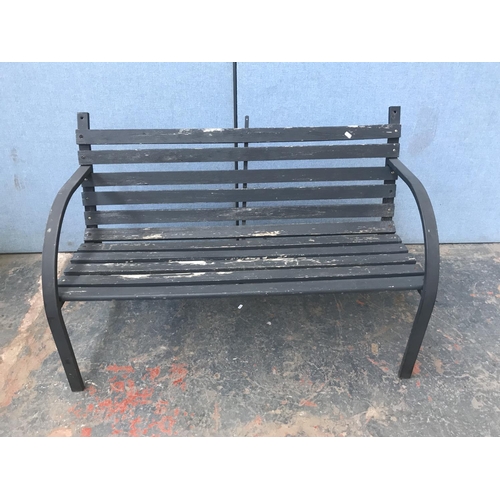 691 - A metal and wooden slatted two seater garden bench - approx. 80cm high x 122cm long x 52cm deep