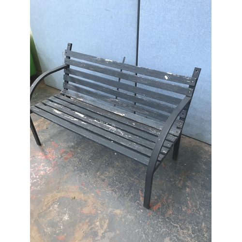 691 - A metal and wooden slatted two seater garden bench - approx. 80cm high x 122cm long x 52cm deep