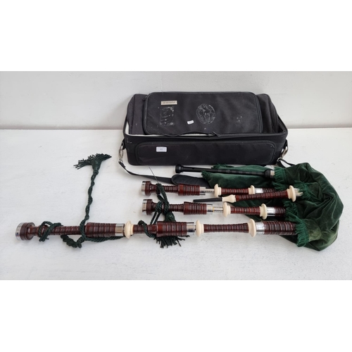 568 - A cased set of great highland bagpipes with accessories to include reeds, bottle trap etc.