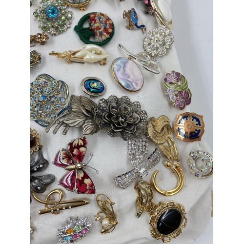 271 - Approx. 100 vintage brooches to include butterfly, filigree, panda etc.