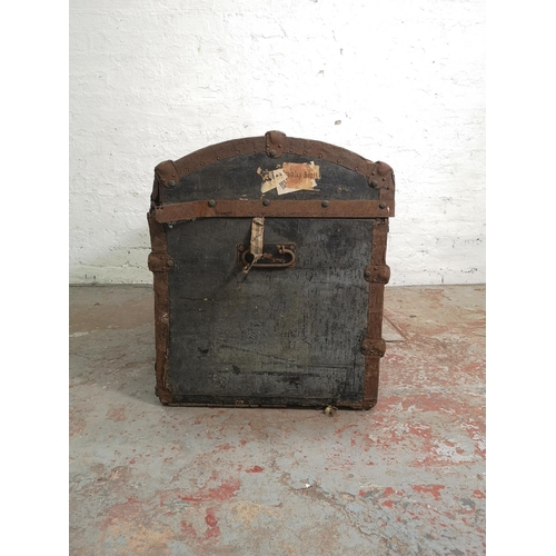 376 - A late 19th/early 20th century wooden and metal banded black canvas travel trunk - approx. 59cm high... 