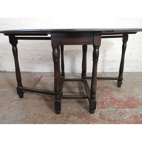 395 - A mid 20th century oak drop leaf gate leg oval dining table - approx. 74cm high x 106cm wide x 154cm... 