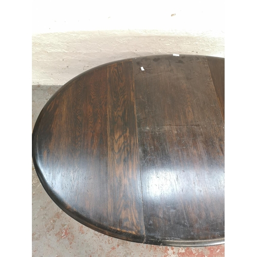 395 - A mid 20th century oak drop leaf gate leg oval dining table - approx. 74cm high x 106cm wide x 154cm... 