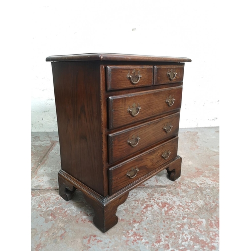 398 - A Georgian style miniature oak chest of two short over three long drawers with brass handles and oge... 