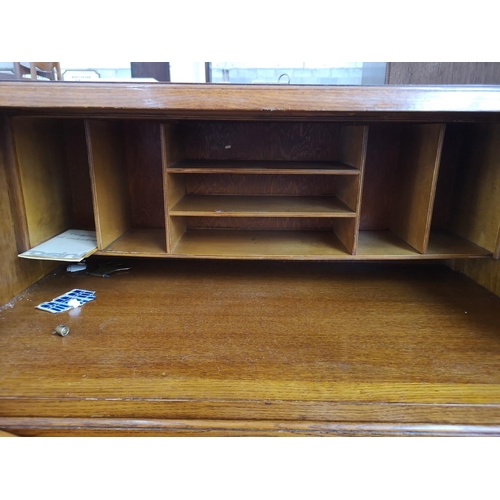 407 - A mid 20th century oak bureau with three drawers, fall front and baluster supports - approx. 101cm h... 