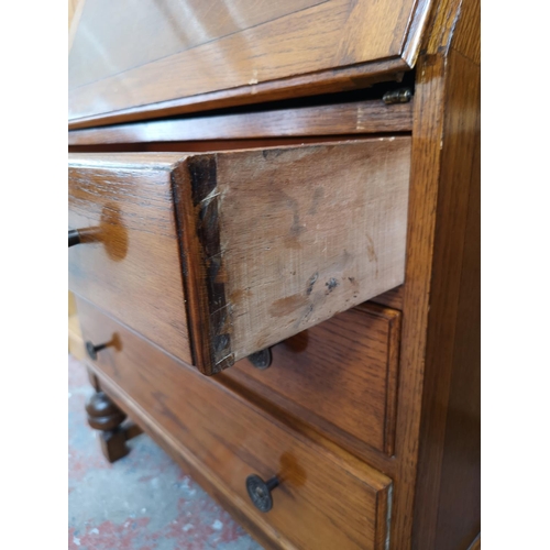 407 - A mid 20th century oak bureau with three drawers, fall front and baluster supports - approx. 101cm h... 