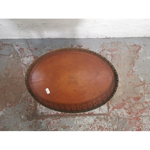 412 - A Regency style mahogany two tier oval side table with brown leatherette inserts and brass galleried... 