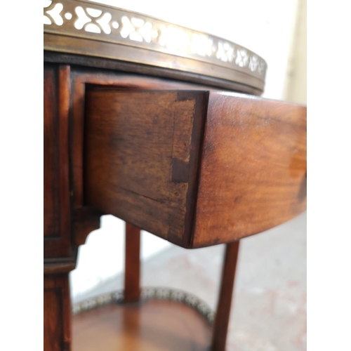 412 - A Regency style mahogany two tier oval side table with brown leatherette inserts and brass galleried... 