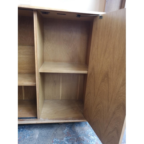 420 - A mid 20th century light oak bookcase with two glass sliding doors, two internal shelves and single ... 