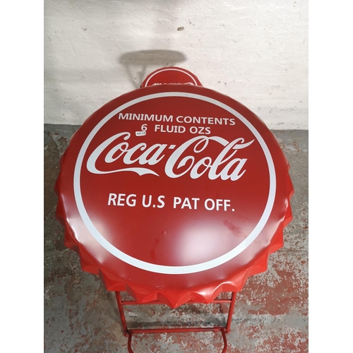 435 - A Coca-Cola red metal folding advertising bistro set with bottle cap design - table approx. 105cm hi... 