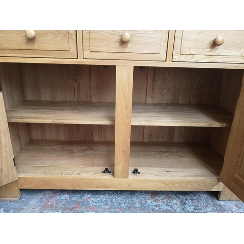 462 - A modern solid oak dresser with two upper bevelled glass doors, three central shelves, three drawers... 