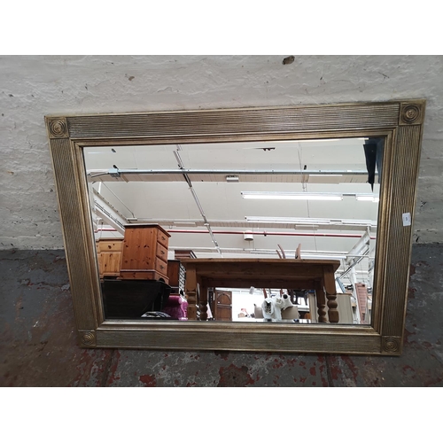 470 - An Arqadia framed bevel edged wall mirror - approx. 110cm wide x 78cm high