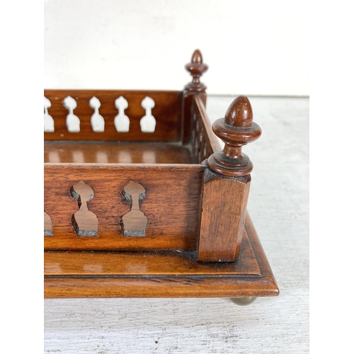 354 - An early 20th century Gothic revival oak galleried tray with brass bun feet - approx. 7cm high x 47c... 