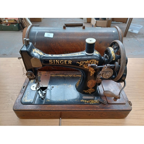 613 - A cased antique Singer hand crank sewing machine (Serial No: F8123225) with attachments