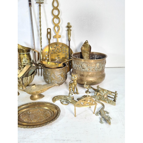 57 - A collection of brassware to include ornamental desk cannon, kettle, jugs etc.