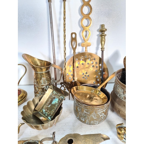 57 - A collection of brassware to include ornamental desk cannon, kettle, jugs etc.