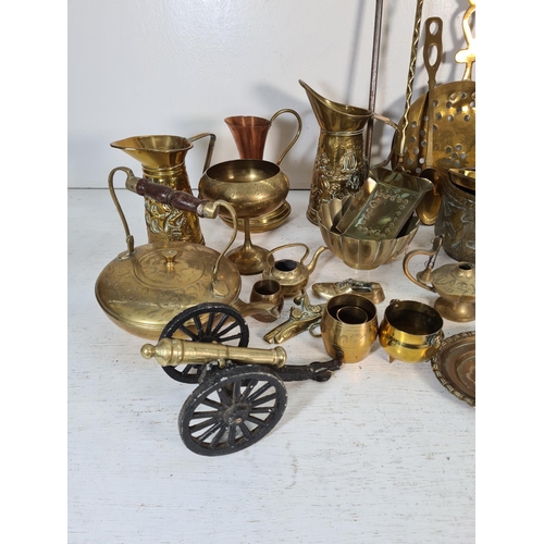 57 - A collection of brassware to include ornamental desk cannon, kettle, jugs etc.