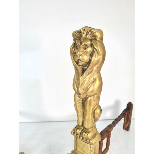 63 - A pair of brass lion design fire dogs - approx. 44cm high x 24cm wide x 42cm deep