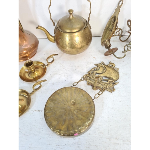 67 - A collection of brass and copper ware to include kettle, wall sconces, chamber sticks etc.