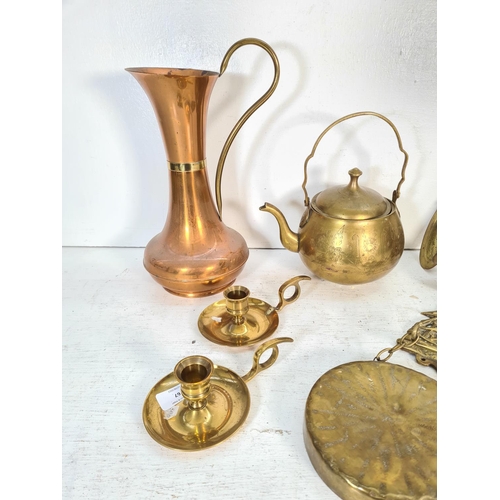 67 - A collection of brass and copper ware to include kettle, wall sconces, chamber sticks etc.