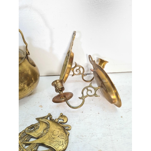 67 - A collection of brass and copper ware to include kettle, wall sconces, chamber sticks etc.