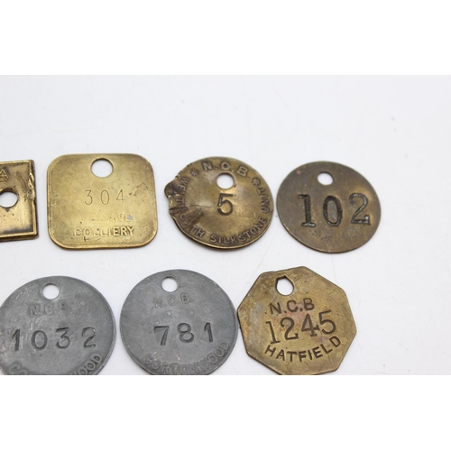 Twelve vintage brass miners and colliery pit check tags