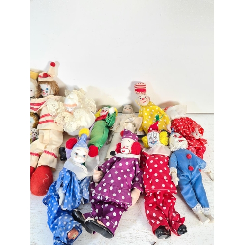 108D - A collection of porcelain headed dolls to include clowns etc.